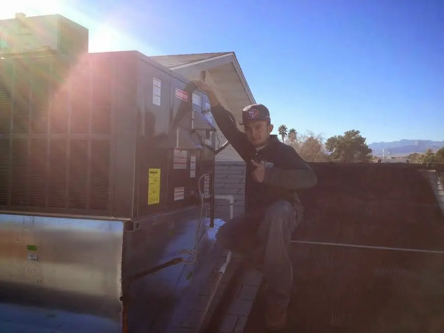 HVAC technician performing HVAC Inspection on a rooftop unit in Burrillville